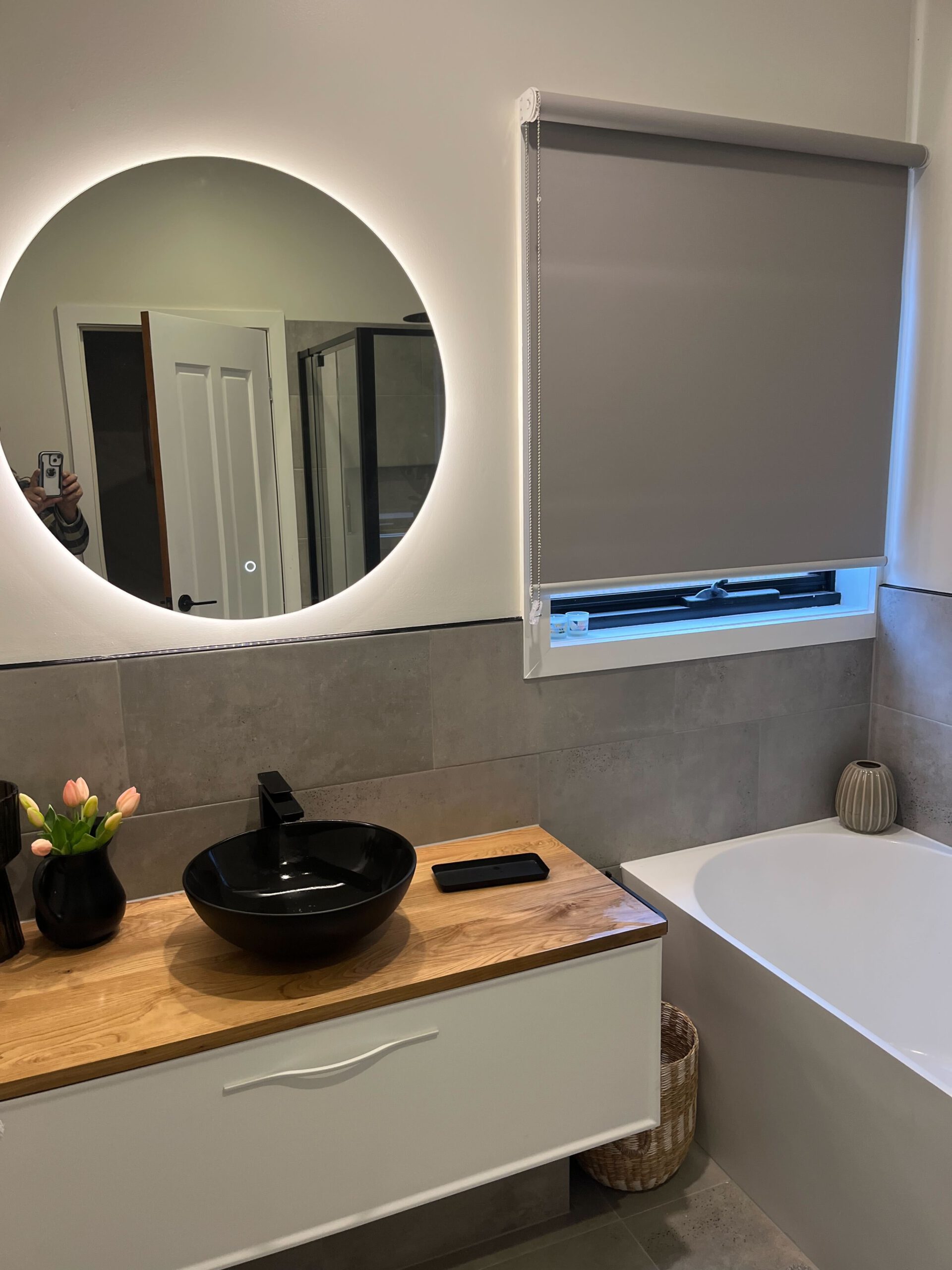 Clean looking Bathroom renovation with round modern LED mirror